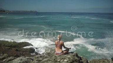 年轻女子坐在莲<strong>花的</strong>姿态，在<strong>海洋</strong>附近沉思